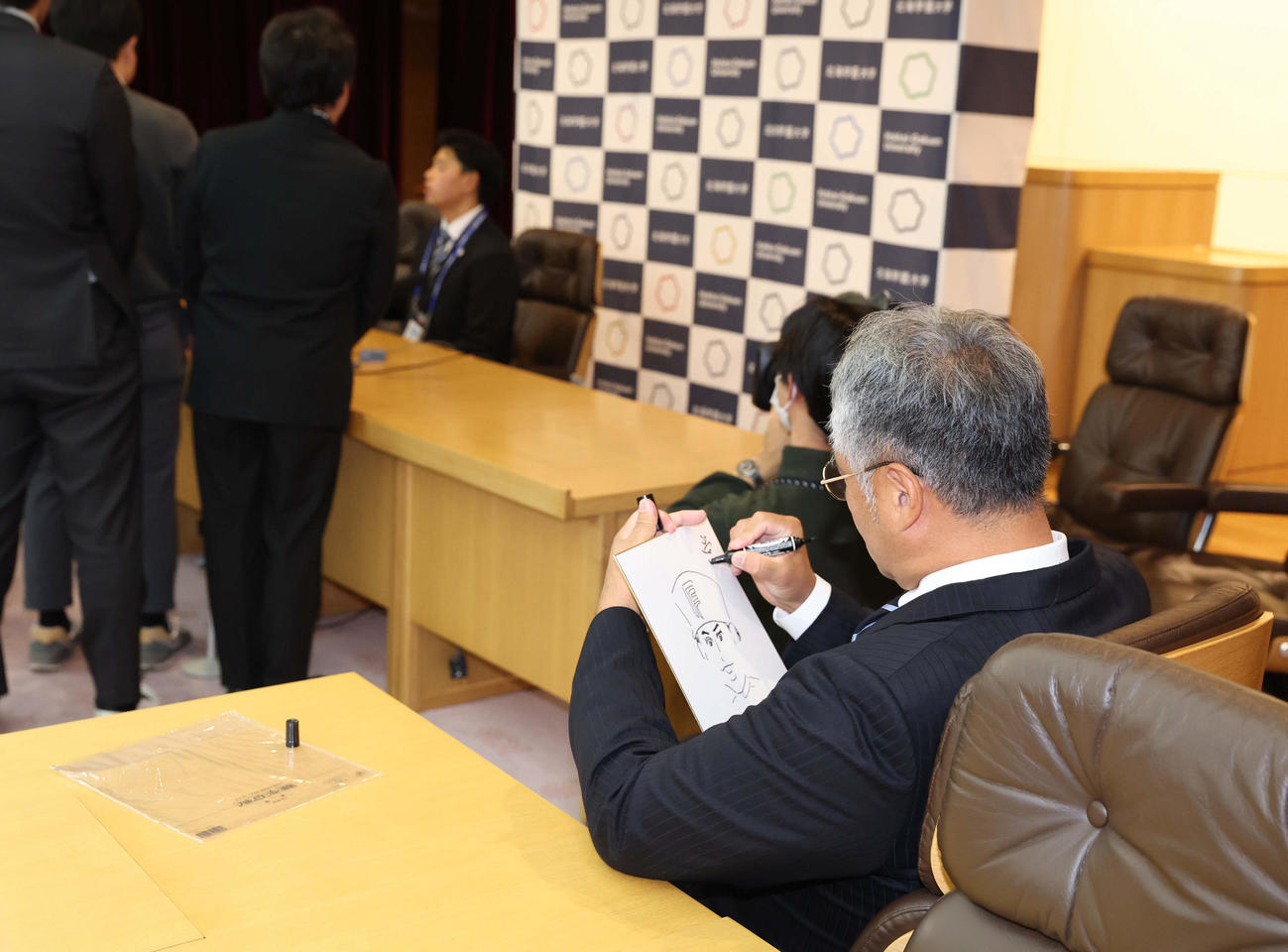 日本ハム育成1位指名の常谷の会見で色紙に似顔絵を書く木田GM代行（撮影・黒川智章）