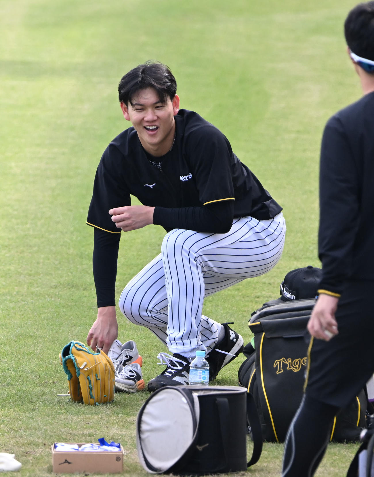 練習中、笑顔を見せる阪神及川（撮影・和賀正仁）
