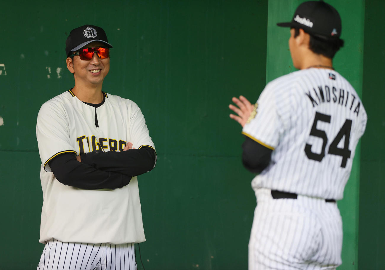 ブルペンで阪神藤川監督（左）は木下と笑顔で話す（撮影・上山淳一）