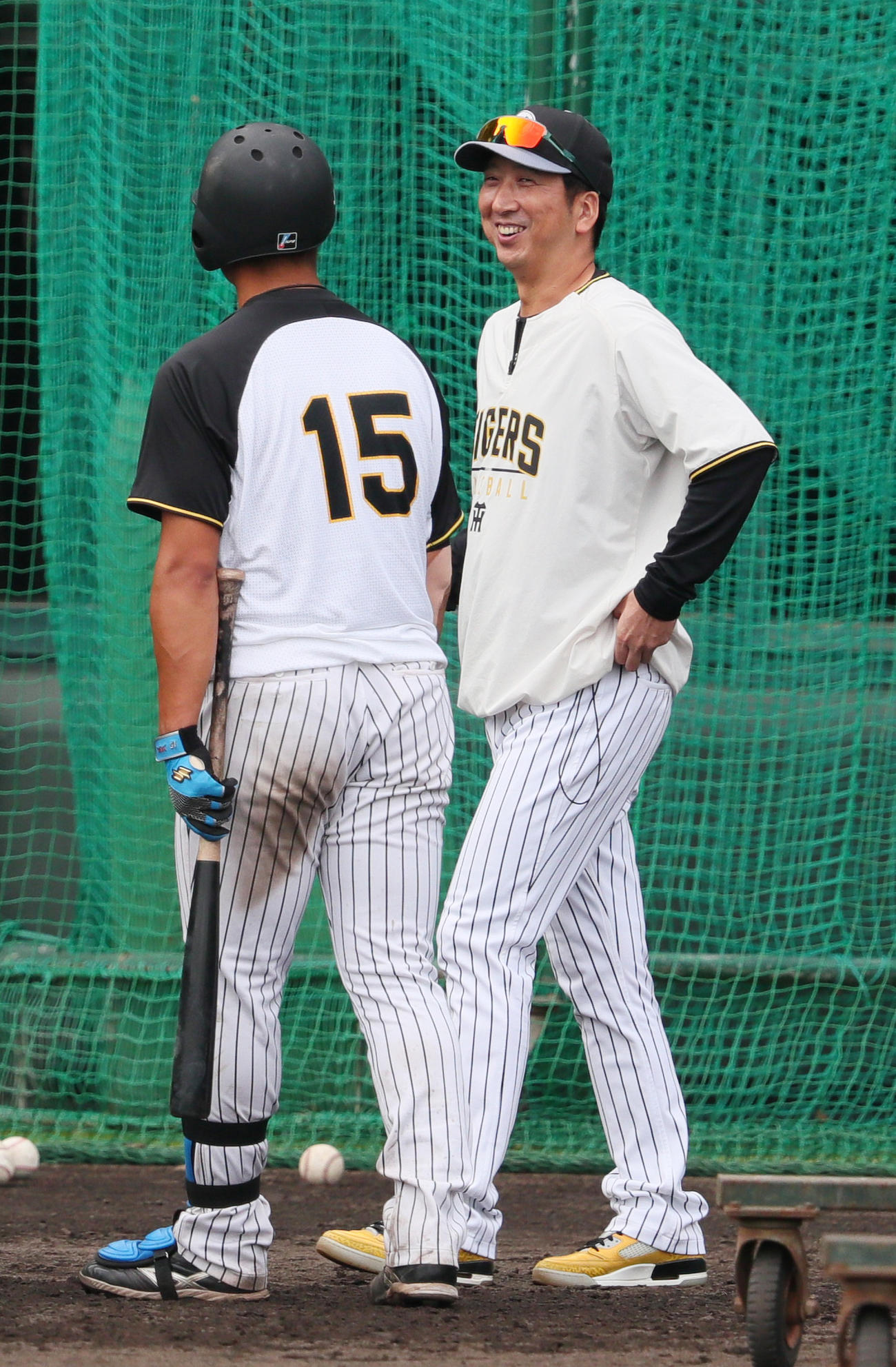 打撃練習の阪神西純（左）に笑顔を見せる藤川監督（撮影・上山淳一）