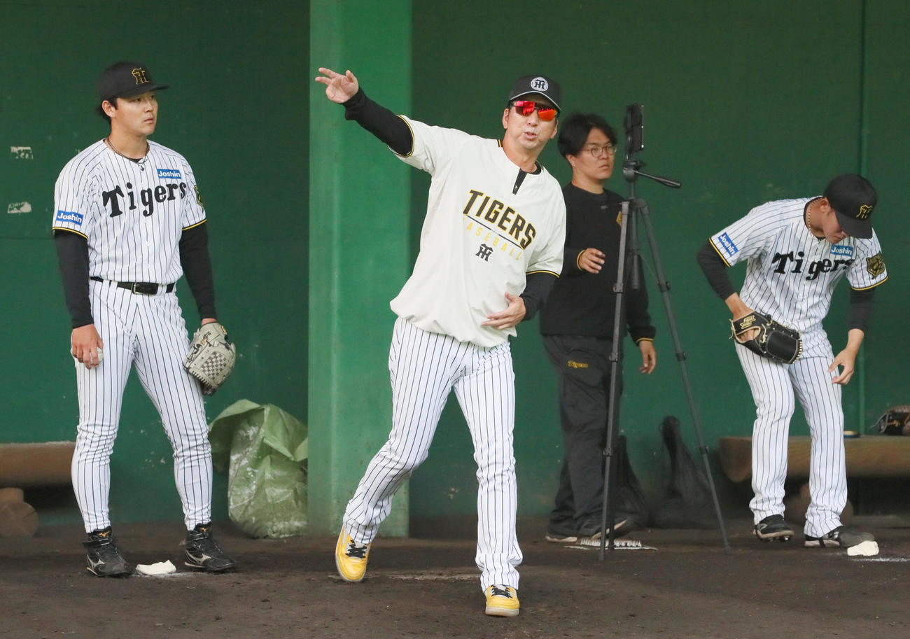 ブルペンで阪神藤川監督（左から2人目）は木下（左）を指導する（撮影・上山淳一）