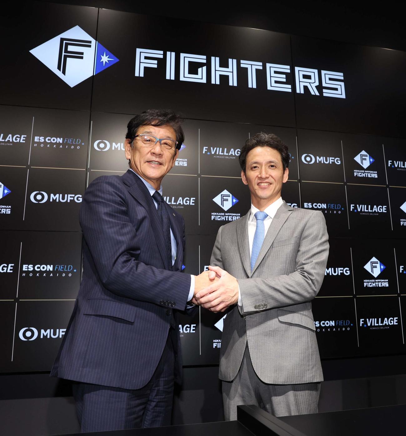 日本ハム1軍野手コーチに就任し栗山CBO（左）と握手する松本氏（撮影・黒川智章）