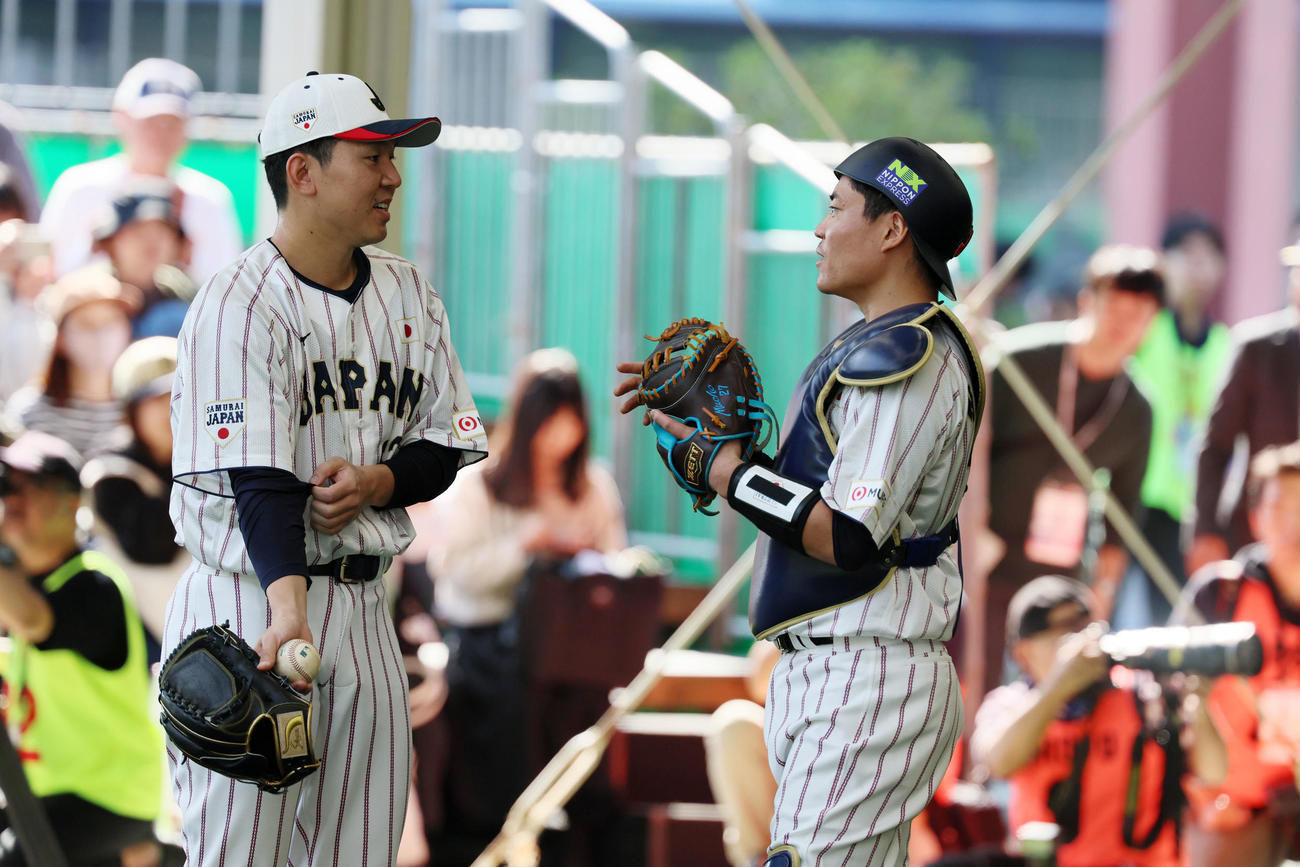 ブルペンで投球練習を終えた西口（左）と話す中村（撮影・加藤哉）