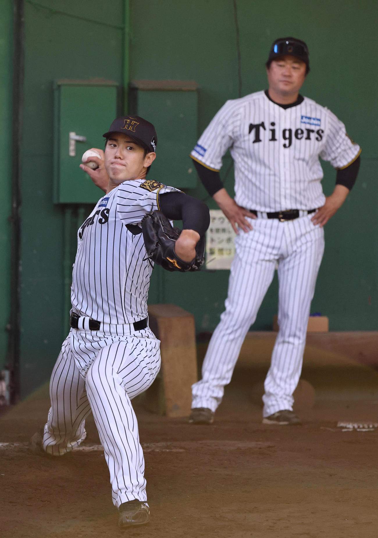 安藤コーチのチェックを受けながら投球練習をする石黒（撮影・上田博志）