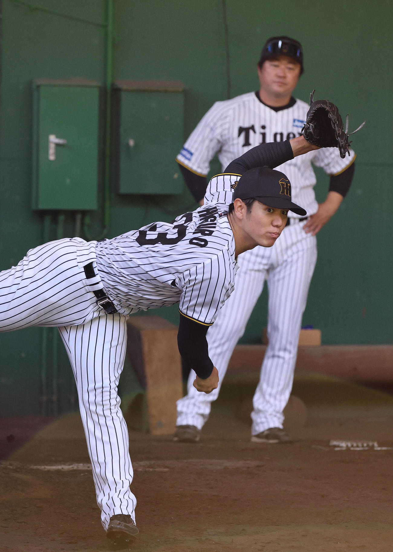安藤コーチのチェックを受けながら投球練習をする石黒（撮影・上田博志）
