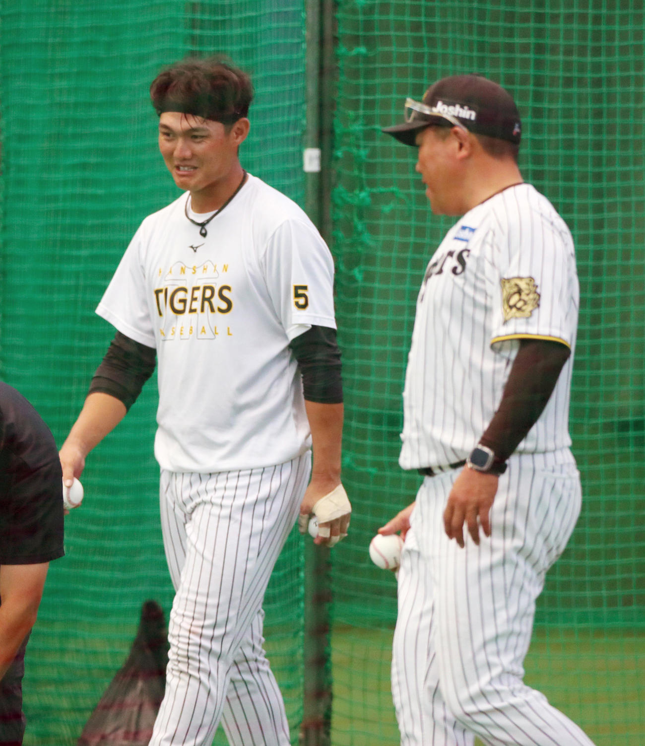 室内で打撃練習を終えた阪神西純（左）は北川2軍打撃コーチと話しながら球拾いする（撮影・上山淳一）