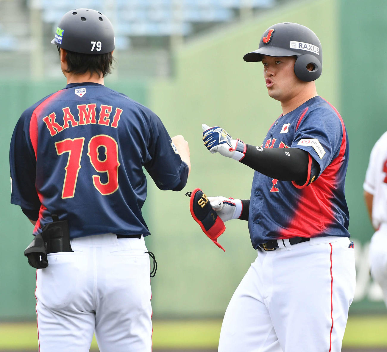 日本対広島　1回表日本無死二塁、先制の左前適時打を放った牧（右）は亀井コーチとタッチを交わす（撮影・岩下翔太）