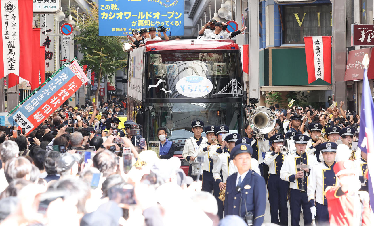 高知市内で行われた阪神タイガース優勝パレードで大勢のファンに手を振る右から藤川監督、ドリス、石井（撮影・上田博志）
