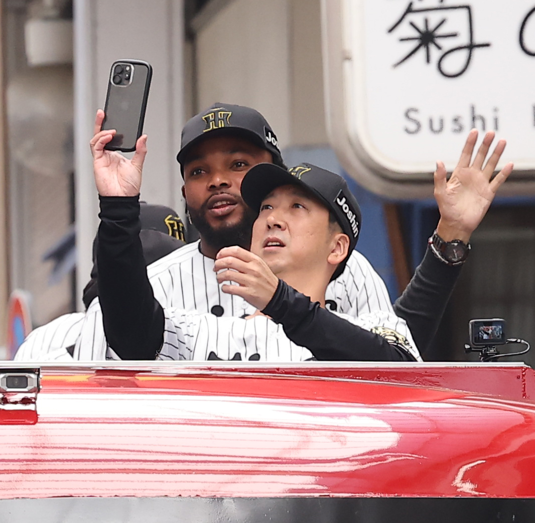 高知市内で行われた阪神タイガース優勝パレードでドリス（左）と記念撮影をする藤川監督（撮影・上田博志）