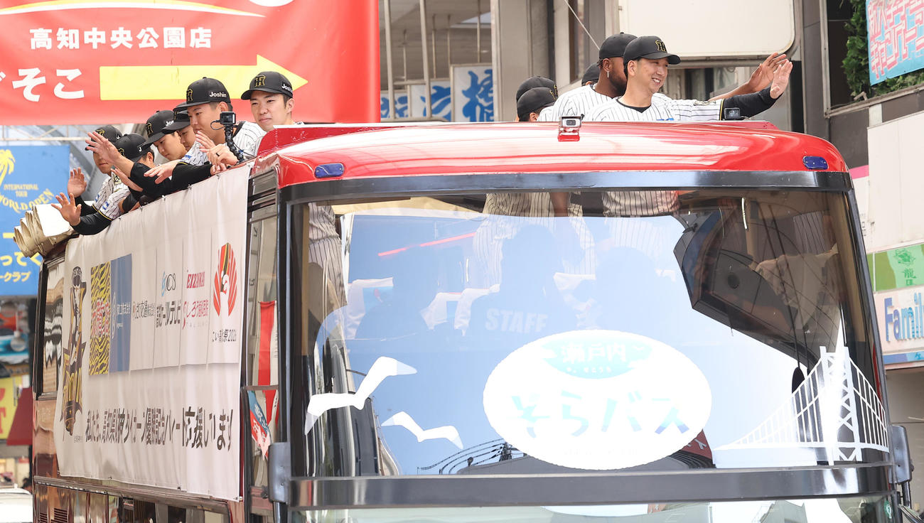 高知市内で行われた阪神タイガース優勝パレードでファンに手を振る藤川監督（右）と石井（左列前）（撮影・上田博志）