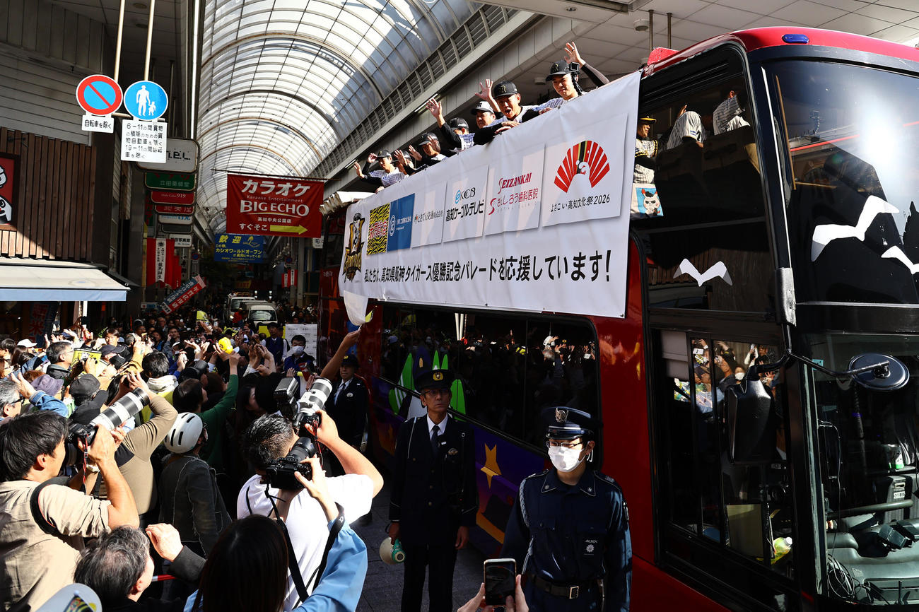 高知市内で行われた阪神タイガース優勝パレードでファンに手を振る右から石井、嶋村、OBの中西清起氏（撮影・上田博志）