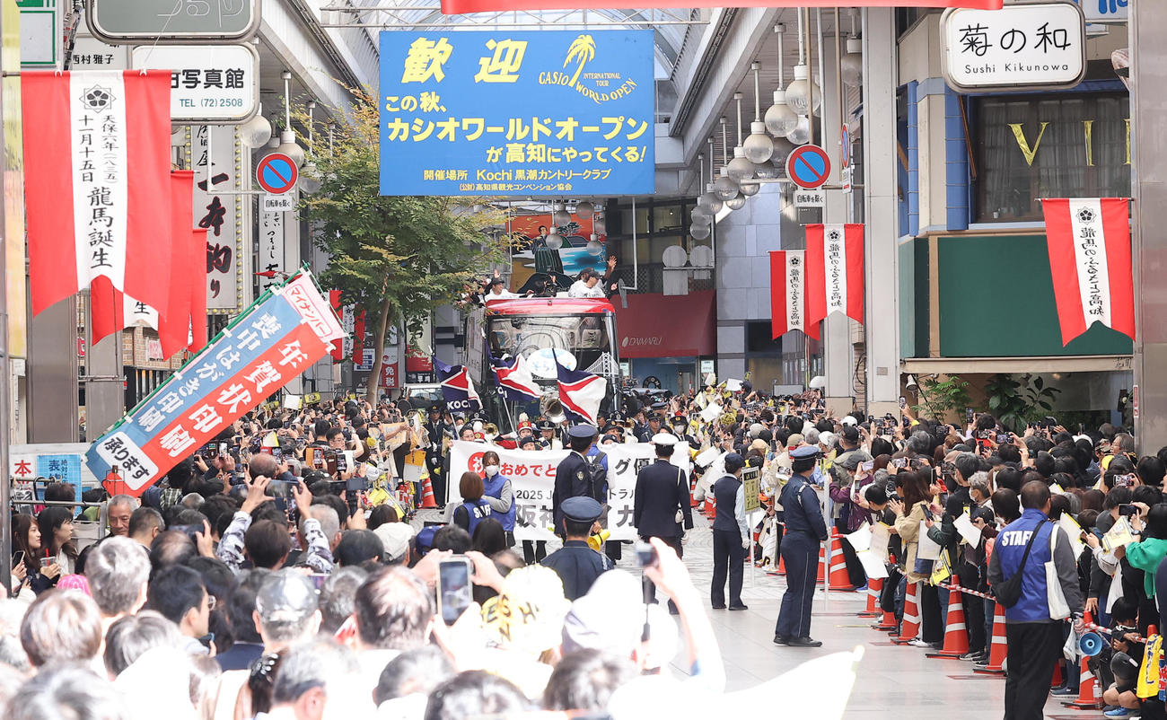 高知市内で行われた阪神タイガース優勝パレードで大勢のファンに手を振る藤川監督（右）と石井（撮影・上田博志）