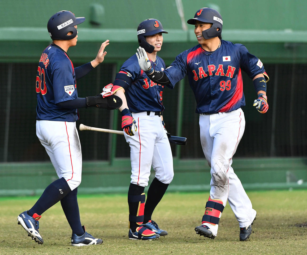 日本対広島　7回表日本無死一塁、左越え2点本塁打を放った野村（右）は、左から岡林、五十幡と笑顔でタッチを交わす（撮影・岩下翔太）