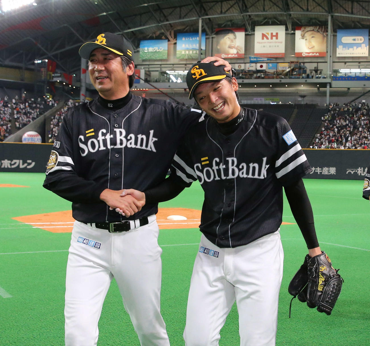 ソフトバンク東浜巨（右）は高山郁夫投手コーチに頭をなでられる（2013年撮影）