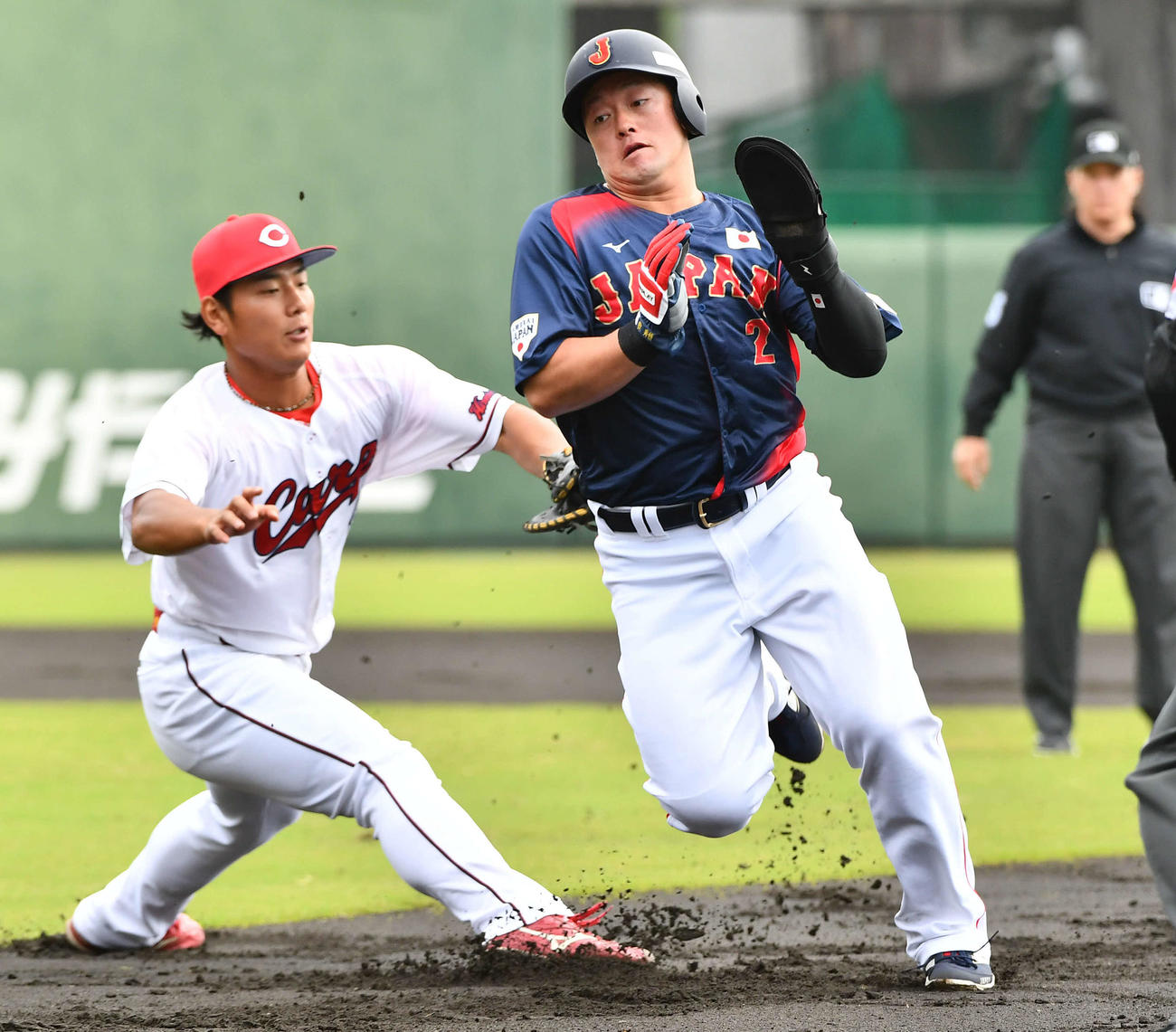 日本対広島　1回表日本無死一塁、けん制で飛び出して塁間に挟まれるも、渡辺（左）のタッチをかわして帰塁した牧（撮影・岩下翔太）