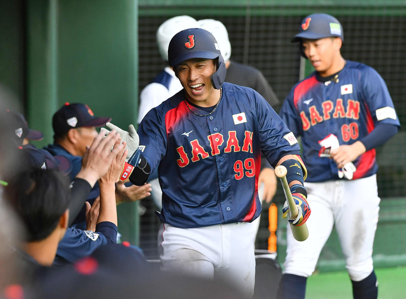 日本対広島　7回表日本無死一塁、左越え2点本塁打を放ち、ナインと笑顔でタッチを交わす野村（撮影・岩下翔太）