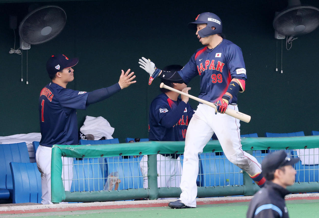 日本対広島　7回表日本無死一塁、野村は左越え2点本塁打を放ちベンチの森下（左）とタッチする（撮影・加藤哉）