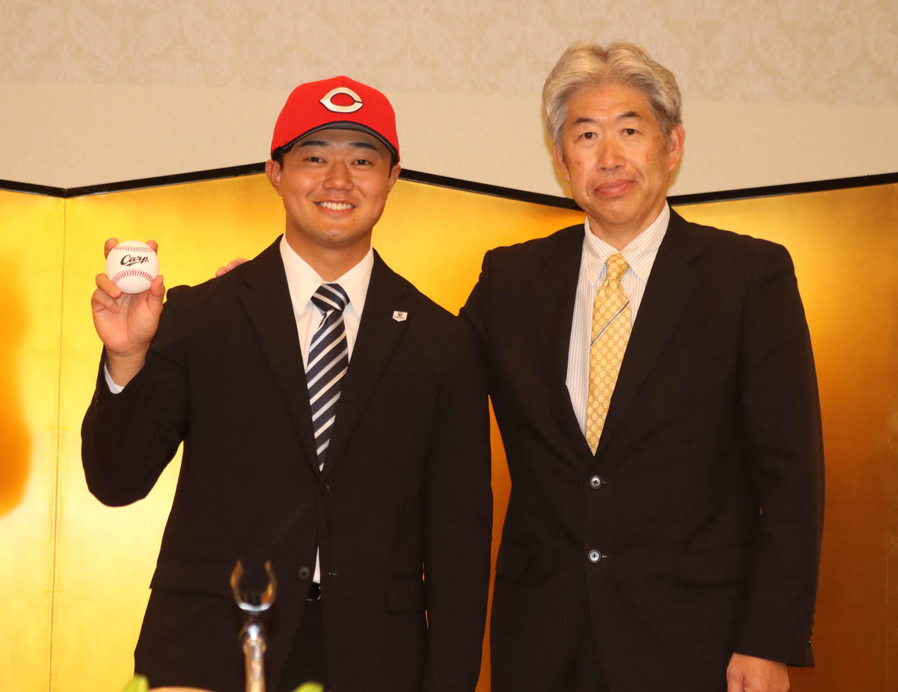仮契約に臨んだ広島ドラフト4位指名の北海学園大・工藤（左）。右は近藤スカウト（撮影・保坂果那）