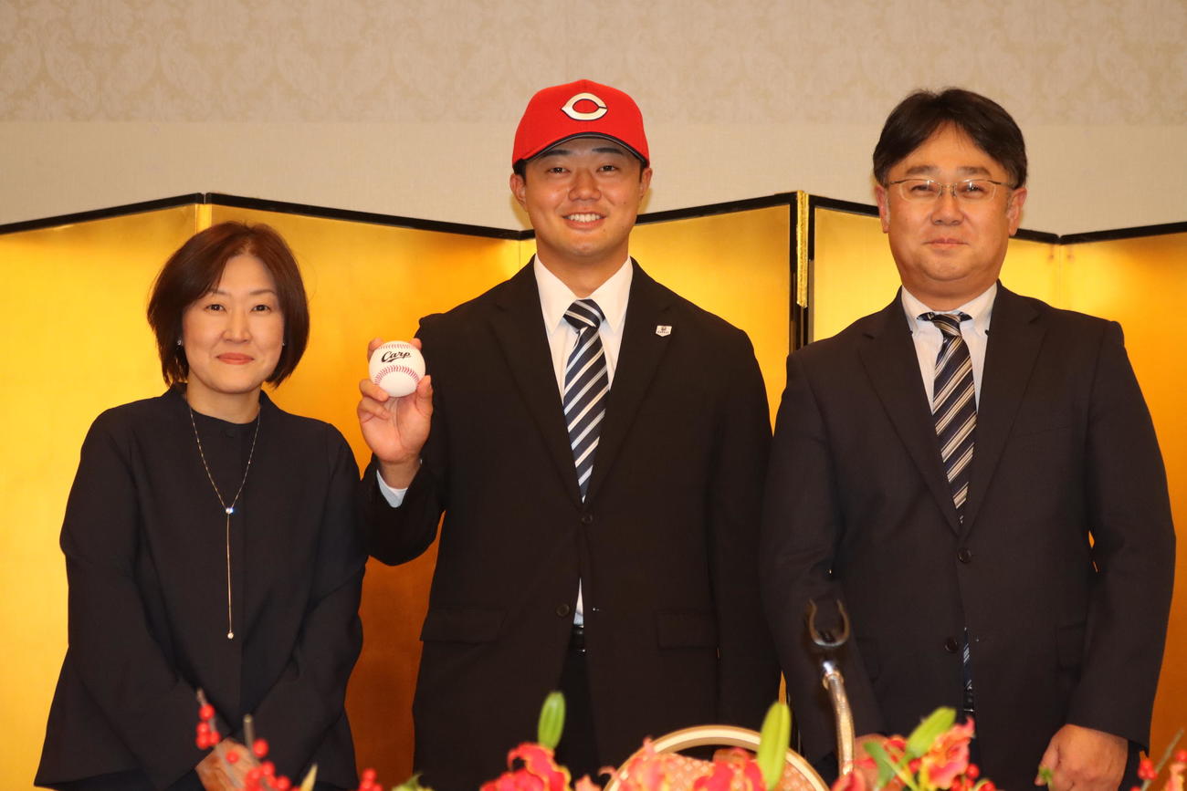 仮契約に臨んだ広島ドラフト4位指名の北海学園大・工藤（中央）。左は母真幸さん、右は父典幸さん（撮影・保坂果那）