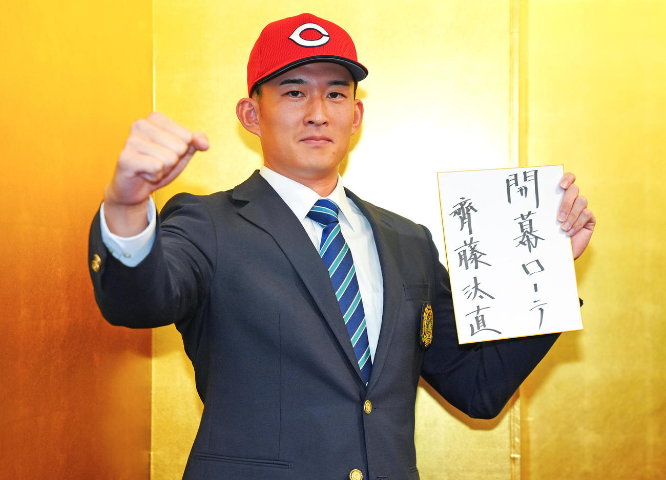 広島との仮契約を終え「開幕ローテ」と記した色紙を手に写真に納まる広島斉藤（撮影・垰建太）