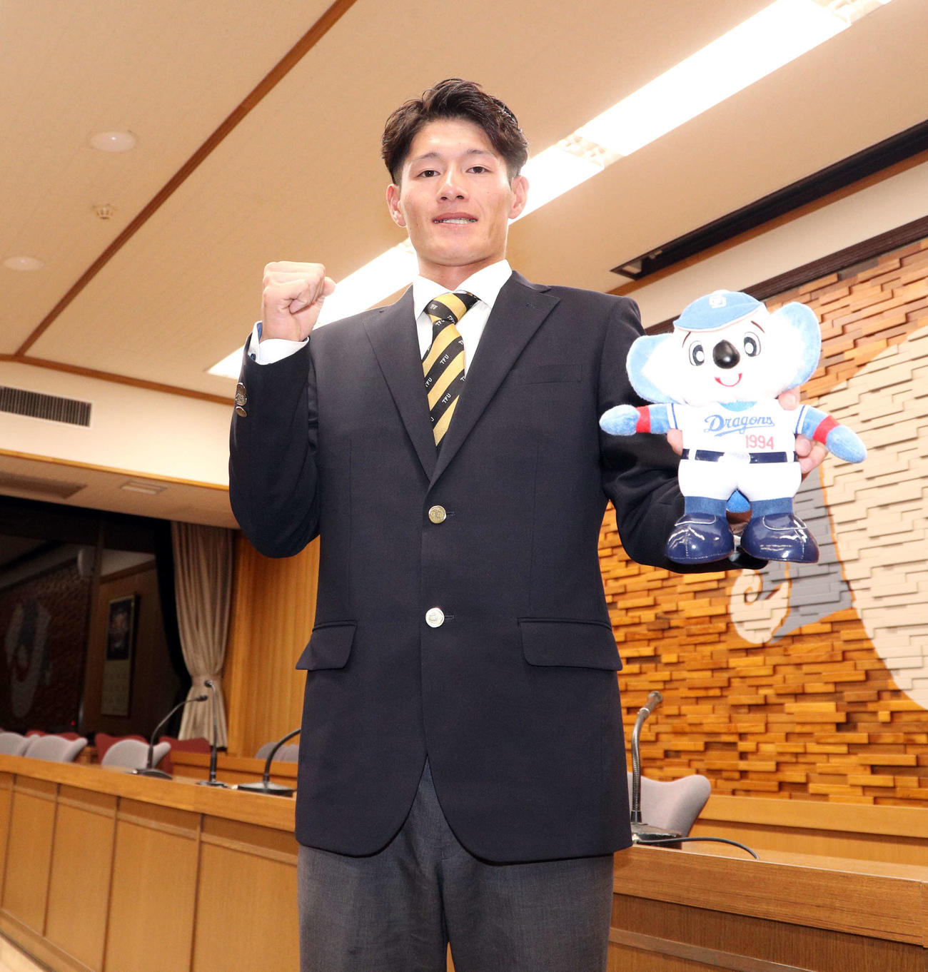 ドラフトで指名を受け球団マスコットを手にガッツポーズする東北福祉大・新保茉良（2025年10月23日撮影）