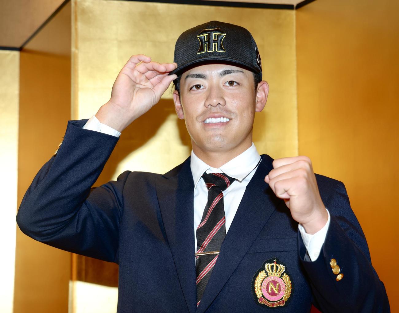 仮契約交渉を終え、ガッツポーズで写真に納まる阪神ドラフト2位の日大・谷端（撮影・河田真司）