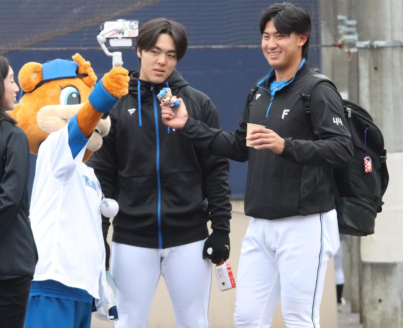 練習後、阪口とともにマスコットのカビーと交流する日本ハム柴田