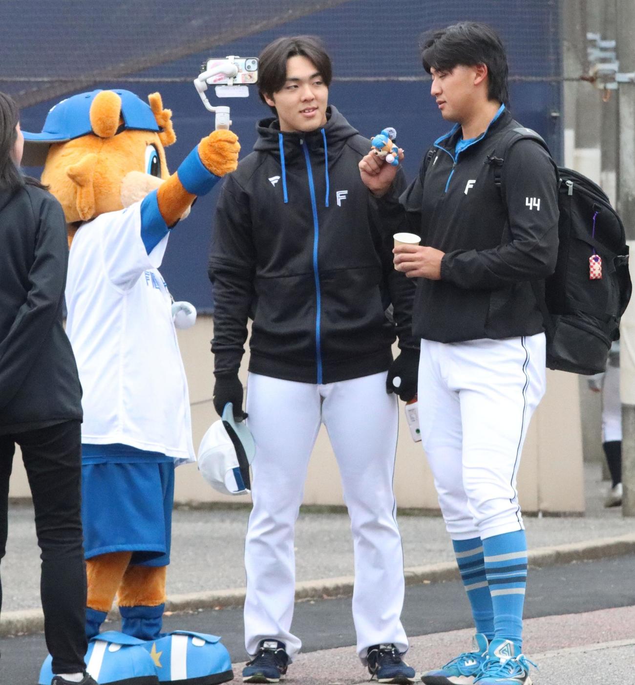 練習後、阪口とともにマスコットのカビーと交流する日本ハム柴田