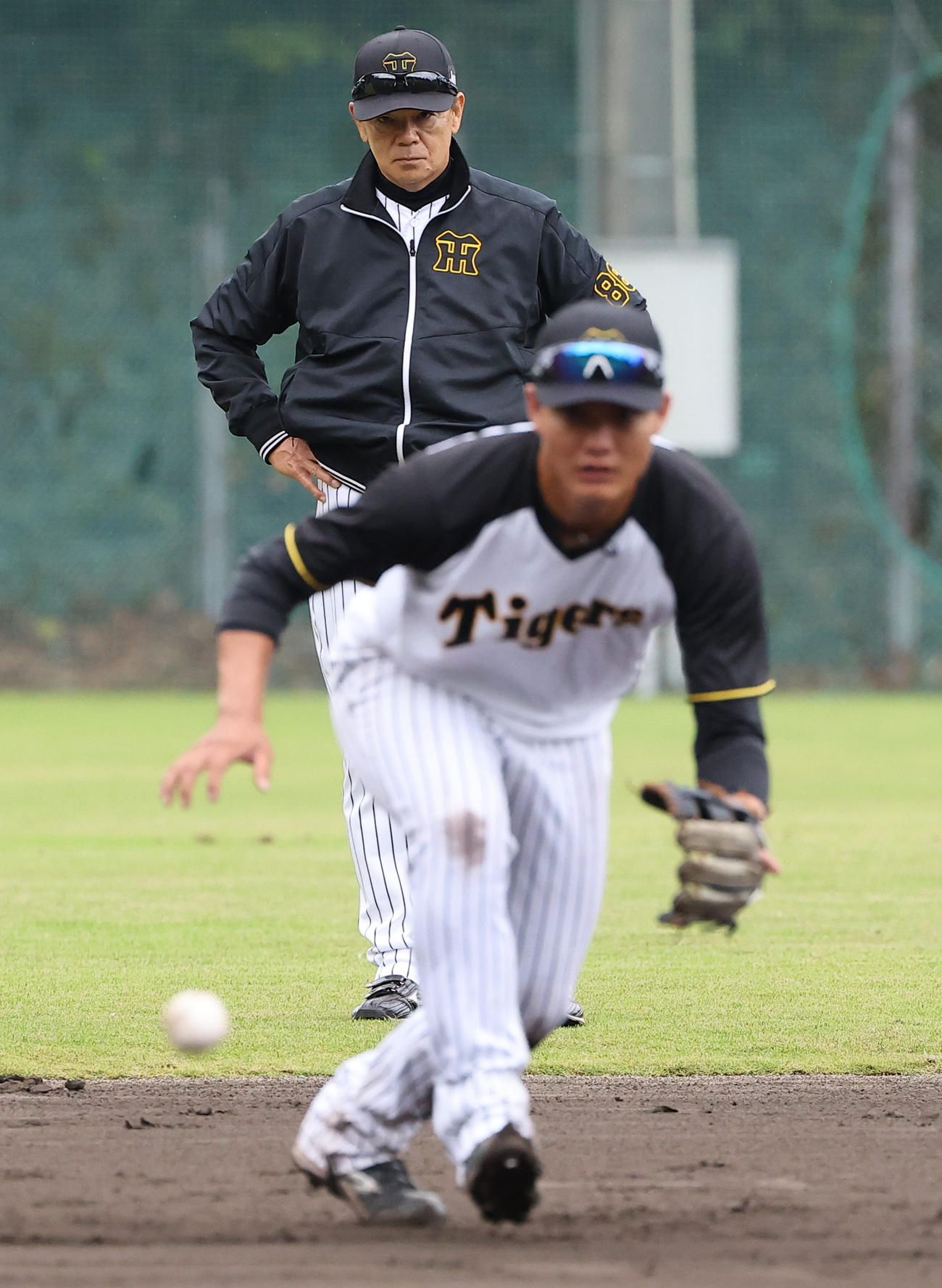 内野ノックを受ける西純（右）の動きをチェックする和田ヘッドコーチ（撮影・上田博志）