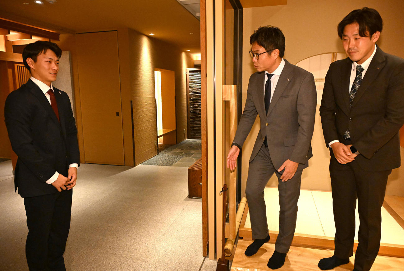 楽天のスカウト部部長愛敬氏（中央）、アマスカウトの足立氏（右）にあいさつをする花園大の藤原（撮影・石井愛子）