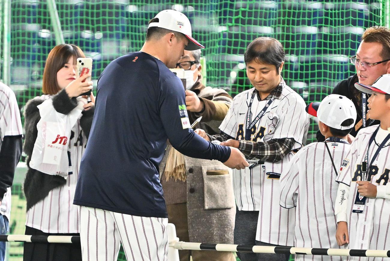 日本対韓国　試合前練習でファンにサインする牧（撮影・滝沢徹郎）