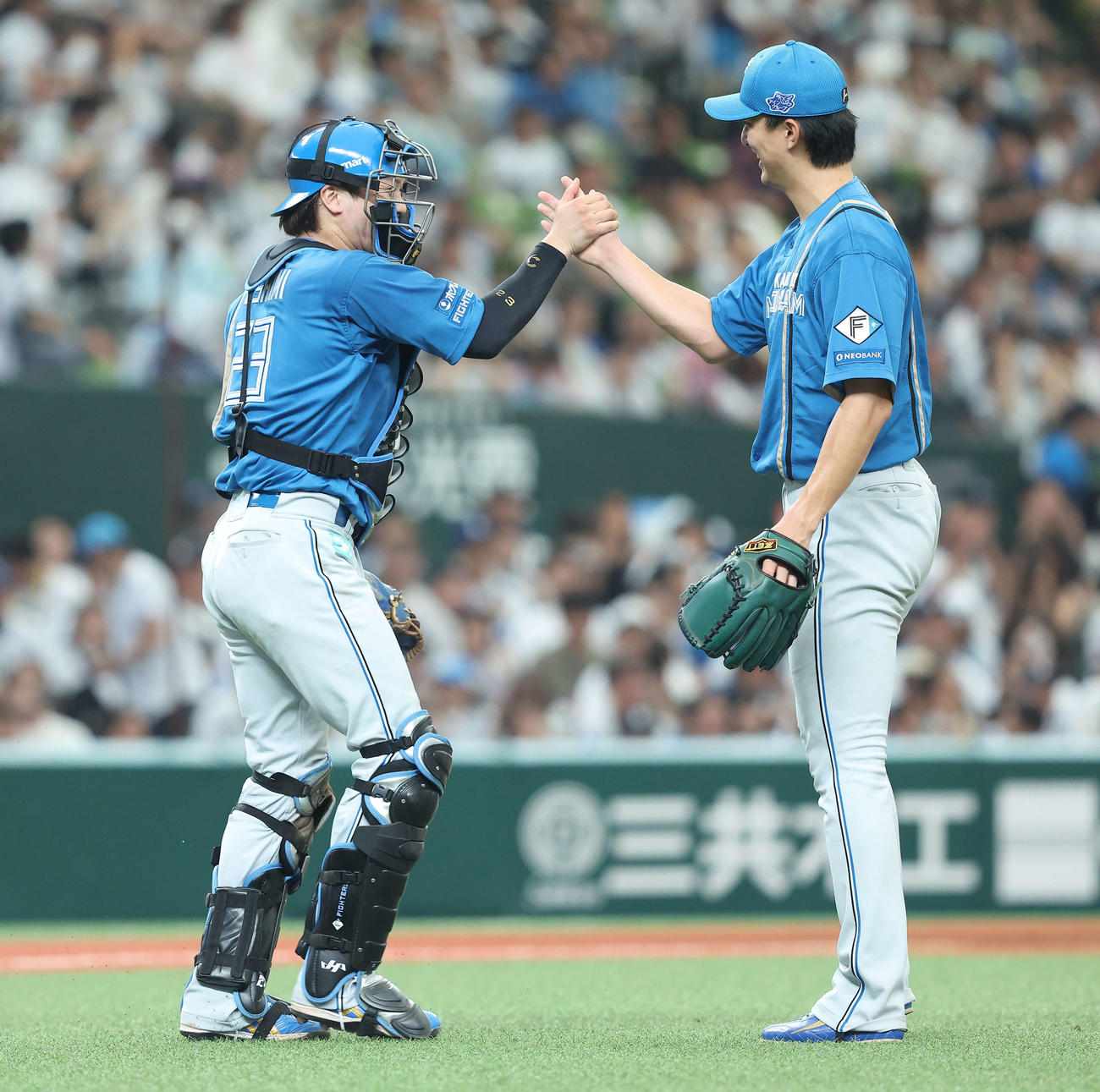 6月29日西武戦で初完投勝利の達孝太とタッチを交わす伏見寅威