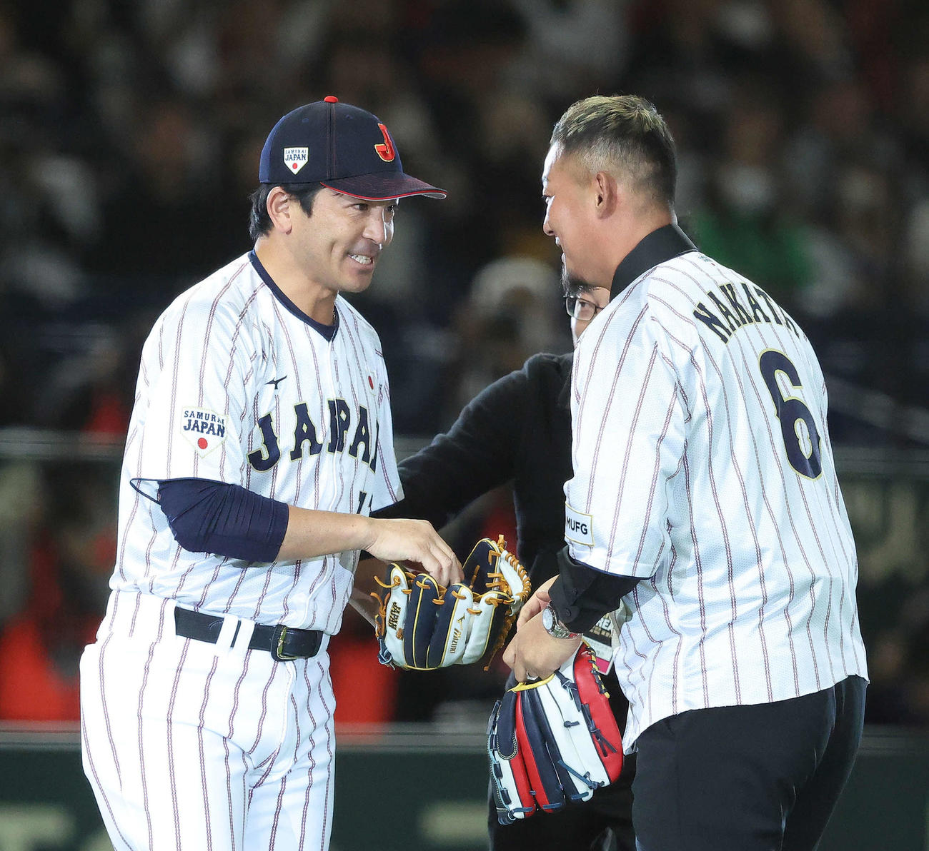日本対韓国　開始前、始球式を務めた中田氏（右）は松田野手総合コーチと言葉を交わす（撮影・河田真司）