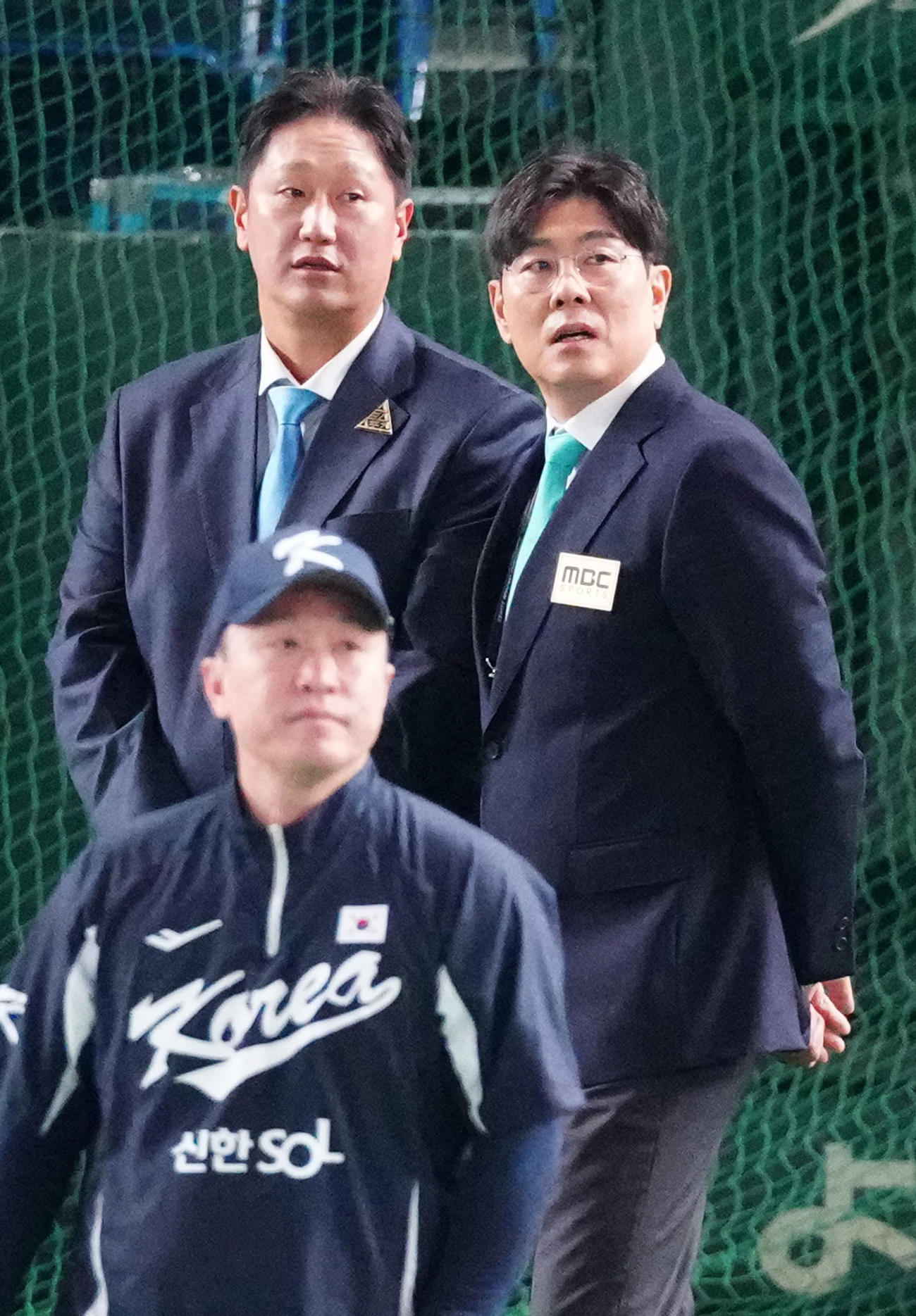 日本対韓国　韓国の試合前練習を見つめる李大浩（イ・デホ）氏（後方左）と鄭■（■は王ヘンに民）哲（チョン・ミンチョル）氏（同右）（撮影・江口和貴）