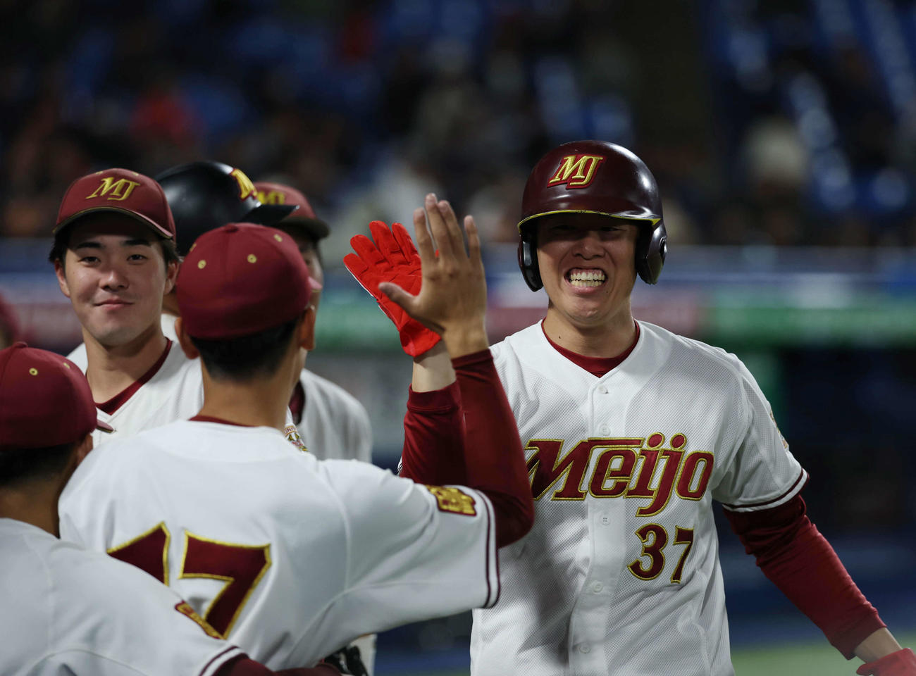 杏林大対名城大　8回裏名城大2死一、三塁、山蔭の適時打で生還しナインとタッチを交わす山田（撮影・増田悦実）