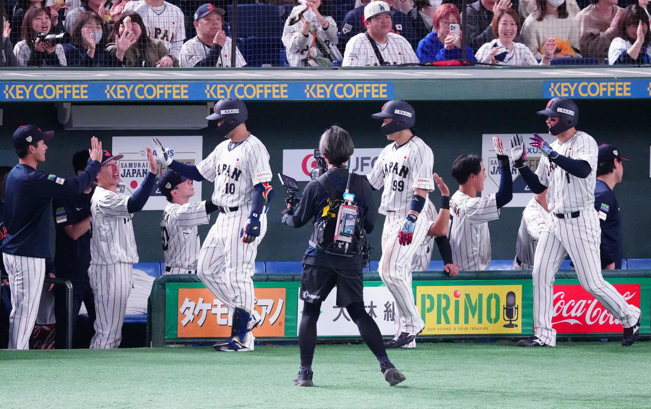 日本対韓国　5回裏日本無死一、二塁、3点本塁打を放ちタッチを交わす代打岸田（左から4人目）（撮影・江口和貴）