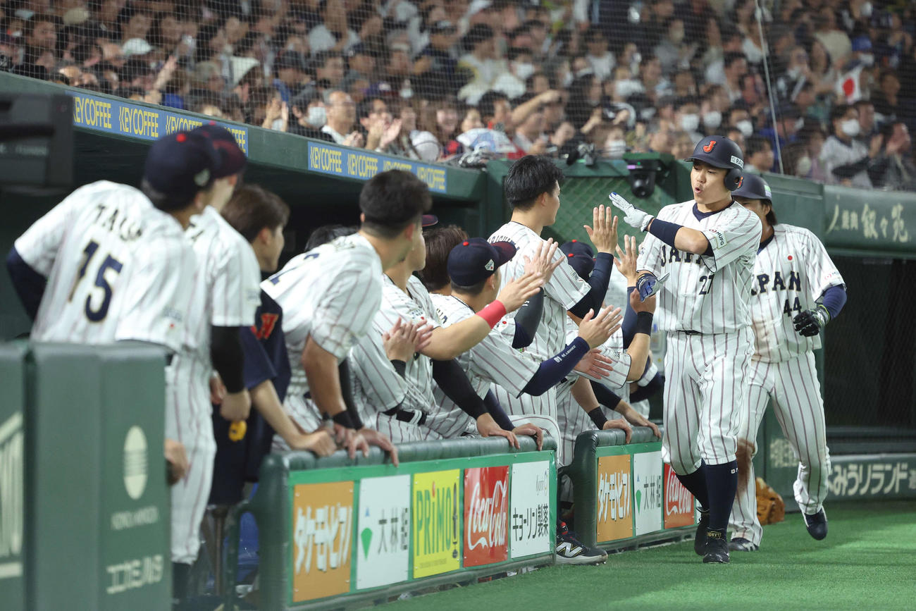日本対韓国　4回裏日本2死二、三塁、西川の2点同点適時二塁打で生還し、チームメートに迎えられる中村（右から2人目）と石上（撮影・河田真司）