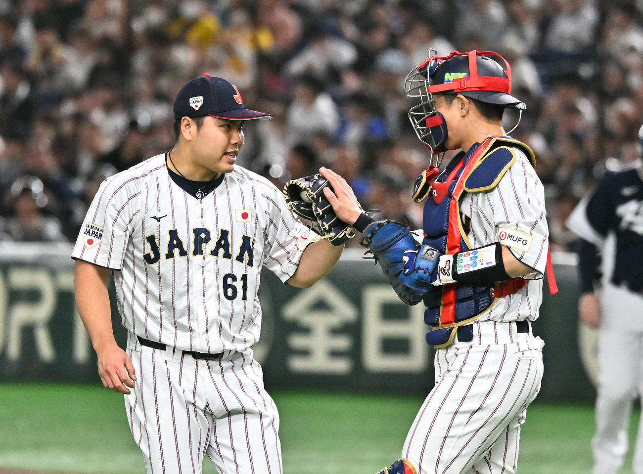 日本対韓国　9回表、日本6番手で登板し試合を締めた平良（左）は若月とタッチを交わす（撮影・滝沢徹郎）