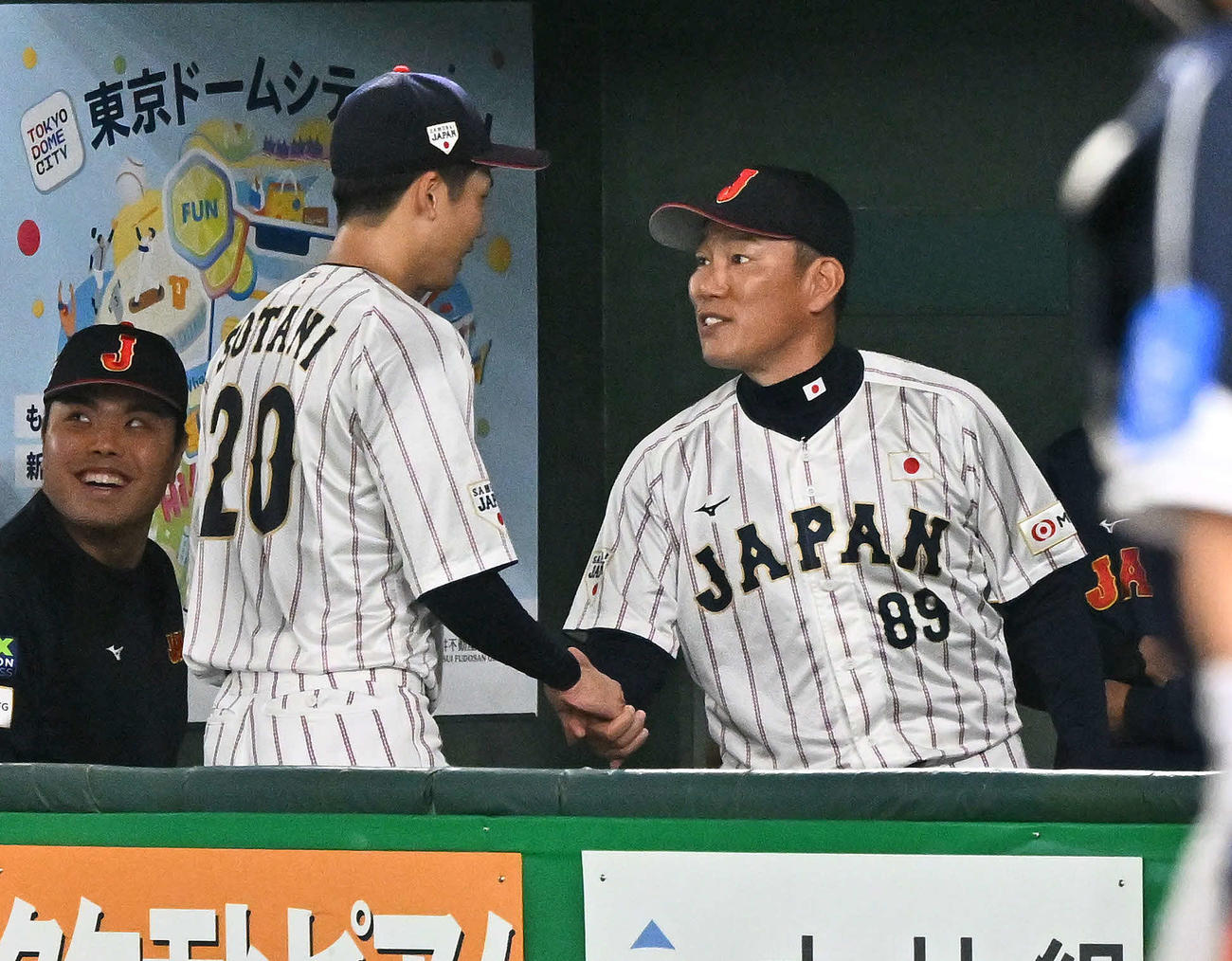 日本対韓国　3回表を終え、侍ジャパン井端監督（右）は先発の曽谷と握手を交わす（撮影・滝沢徹郎）