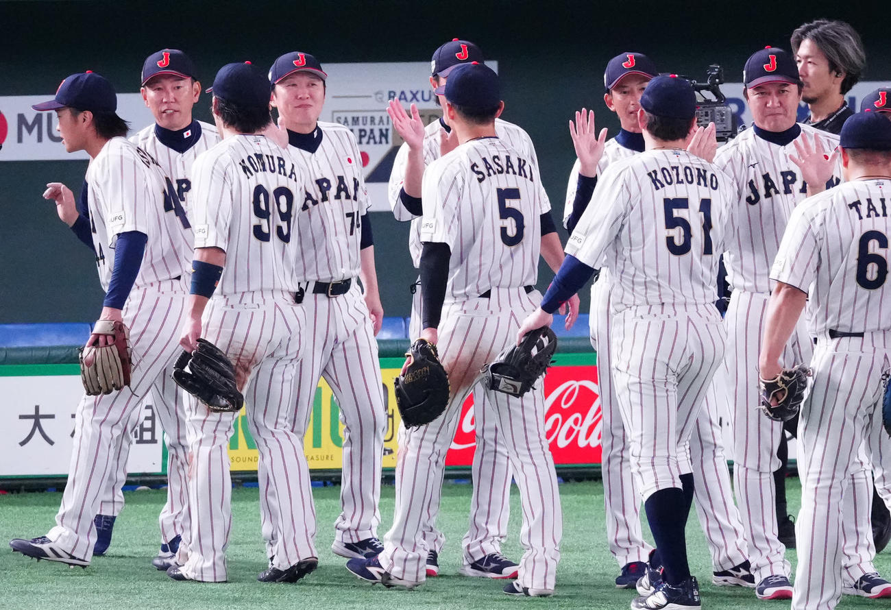 日本対韓国　韓国に勝利し選手たちとタッチを交わす井端監督（左から2人目）（撮影・江口和貴）