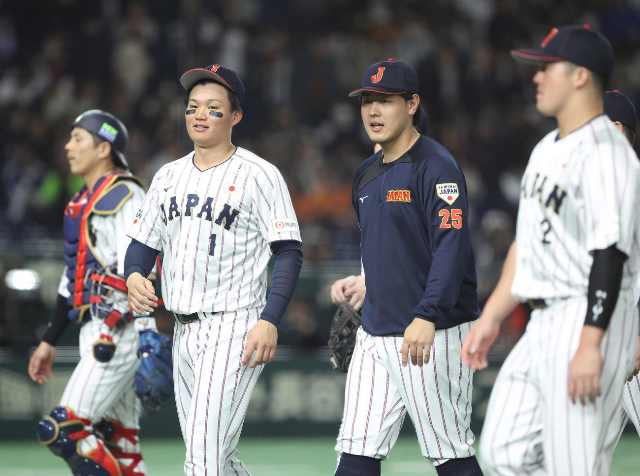 日本対韓国　韓国に勝利し、あいさつを終え、森下（手前左）と言葉を交わしながら引き揚げる岡本（撮影・河田真司）