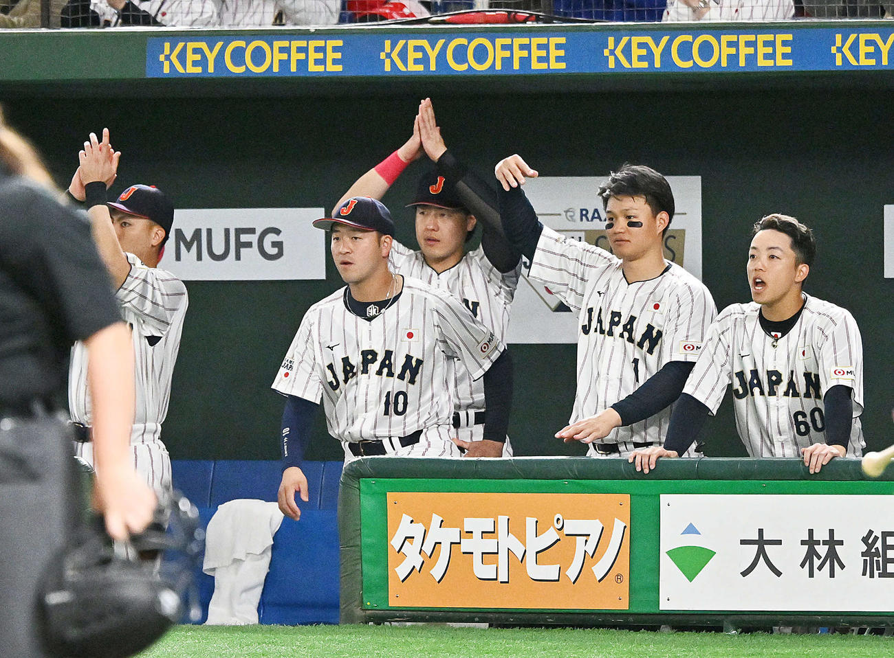 日本対韓国　4回裏日本1死二、三塁、牧の左前適時打に手をたたいて祝福する岡本（後方）（撮影・滝沢徹郎）