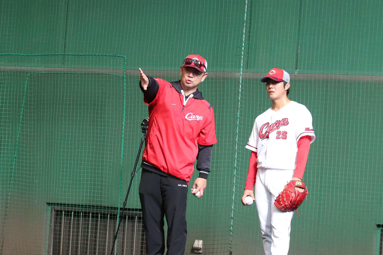 広島益田武尚と話をする日南秋季キャンプ視察中の石井弘寿新投手コーチ（写真左）（撮影・前原淳）