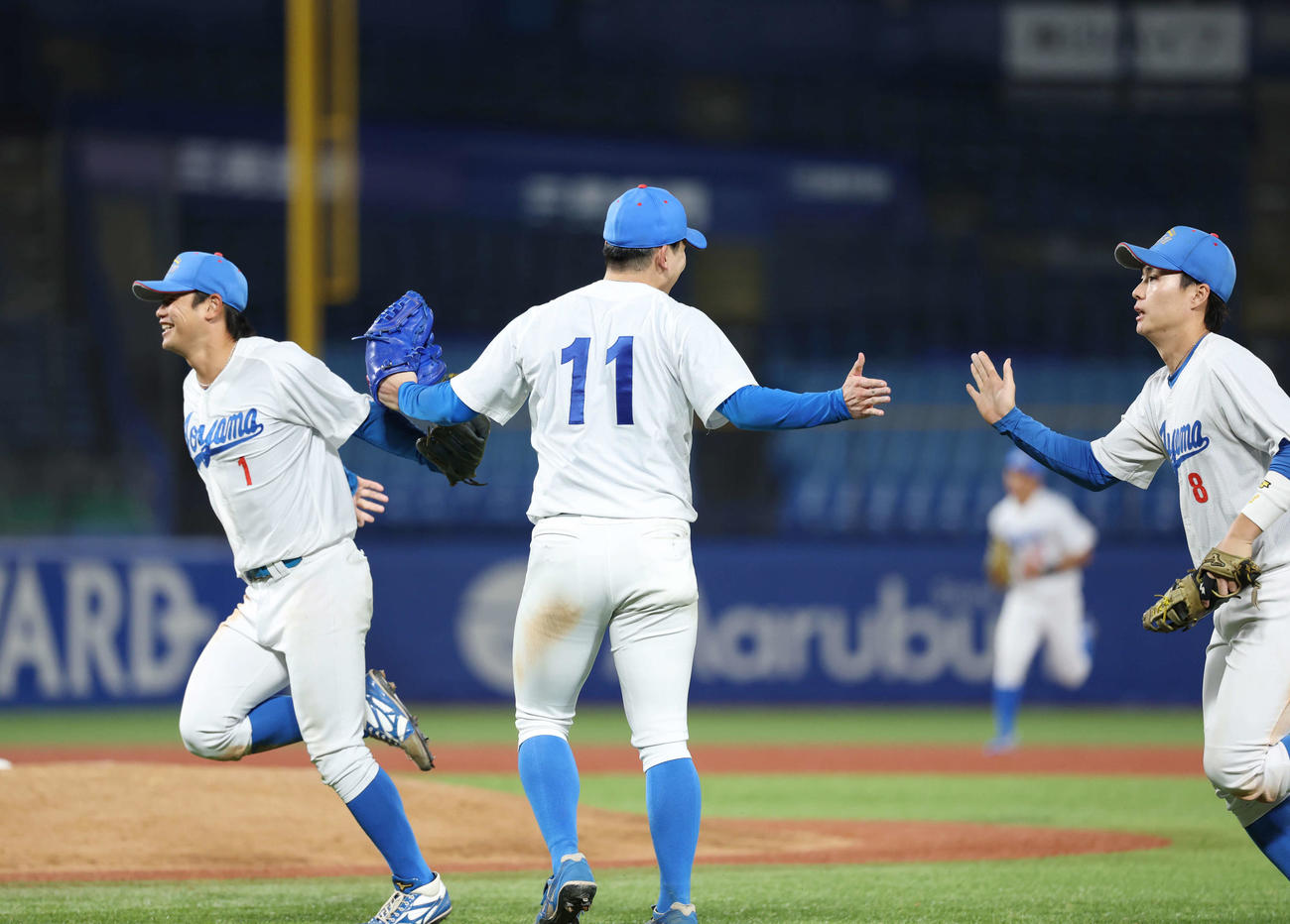 佛教大対青学大　勝利しタッチを交わす左から青学大・藤原、中西、初谷（撮影・増田悦実）