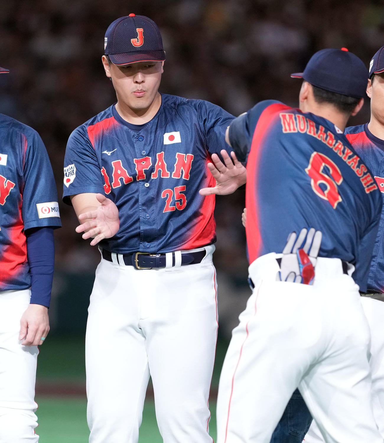 韓国対日本　選手入場で村林（右）とハイタッチをする岡本（撮影・たえ見朱実）