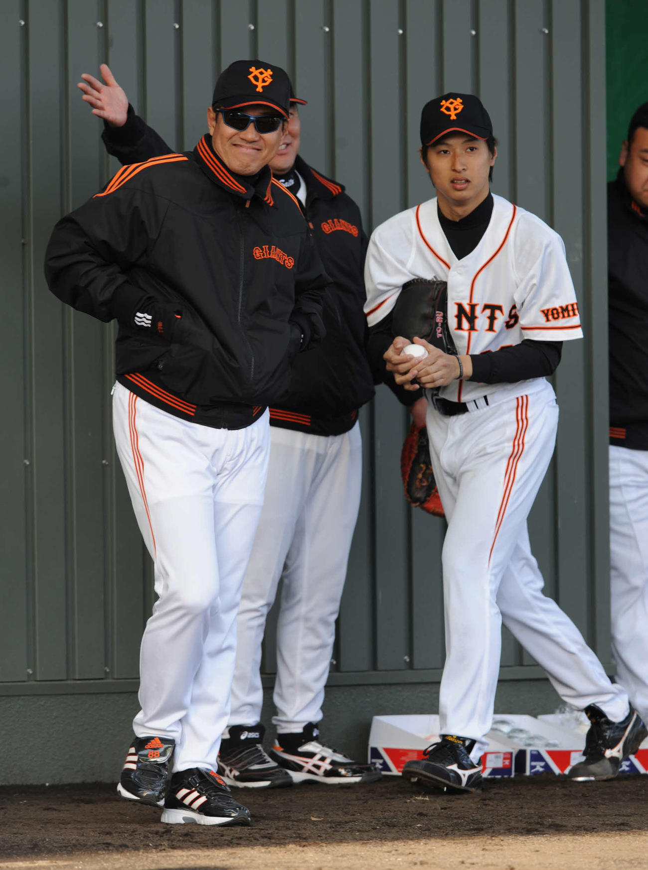 2008年2月、ブルペンで笑顔を浮かべながら投手陣を見守る原辰徳監督。右は村田透