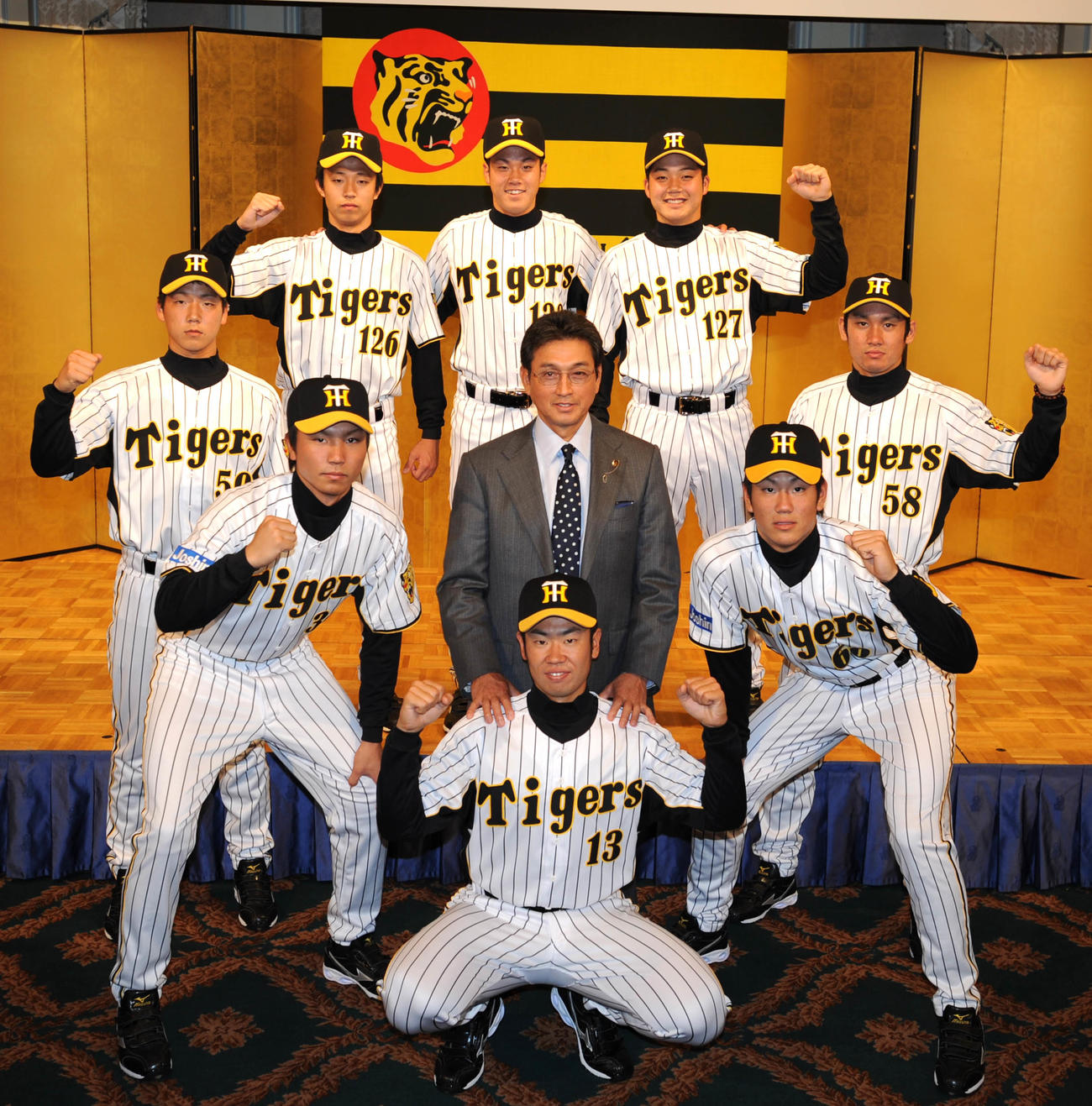 2010年12月6日、真弓明信監督を中心に新入団発表を行う中央下から時計回りに榎田大樹、一二三慎太、岩本輝、島本浩也、阪口哲也、穴田真規、荒木郁也、中谷将大