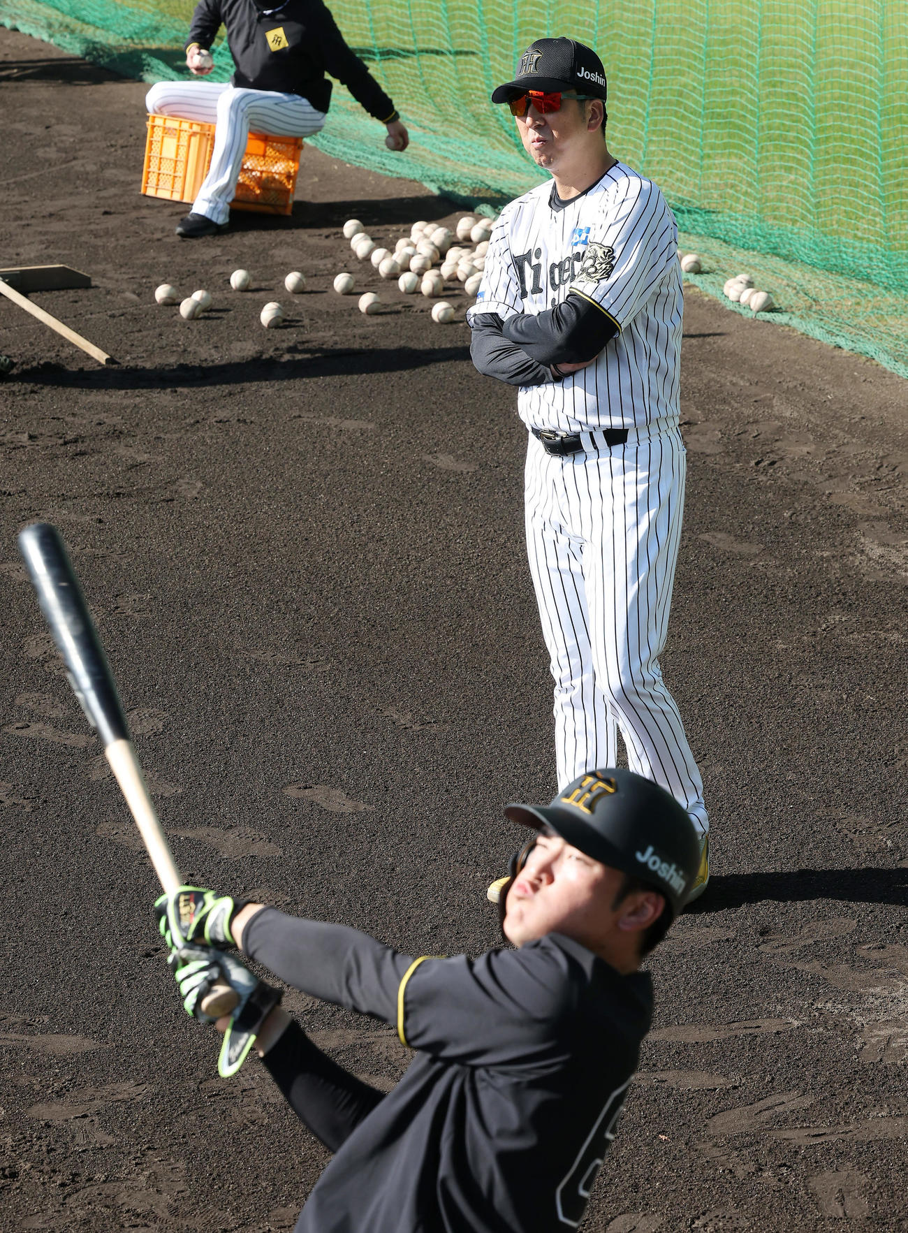 高寺（手前）の打撃練習を見守る阪神藤川監督（撮影・前田充）