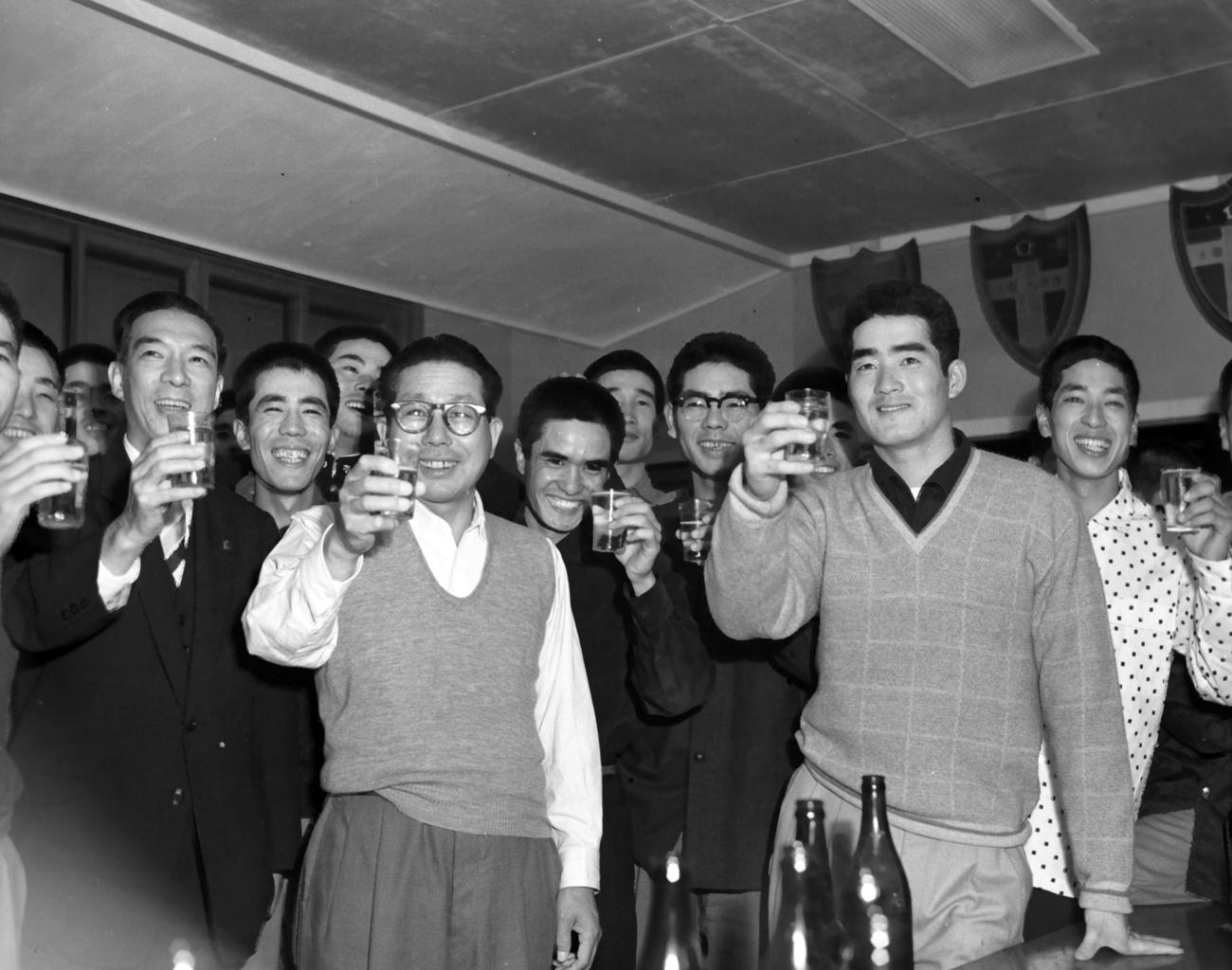 春秋連覇を遂げ合宿所智徳寮で乾杯をする立大ナイン。中央左から辻猛監督、本屋敷錦吾、杉浦忠、長嶋茂雄（1957年11月3日撮影）