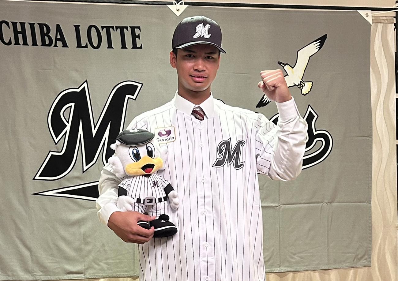 球団マスコットマーくんを持ちガッツポーズをするドラフト4位の桜井（撮影・星夏穂）